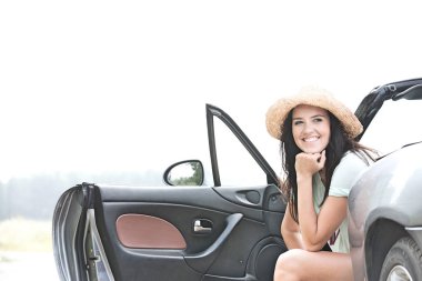 Happy woman sitting in convertible clipart