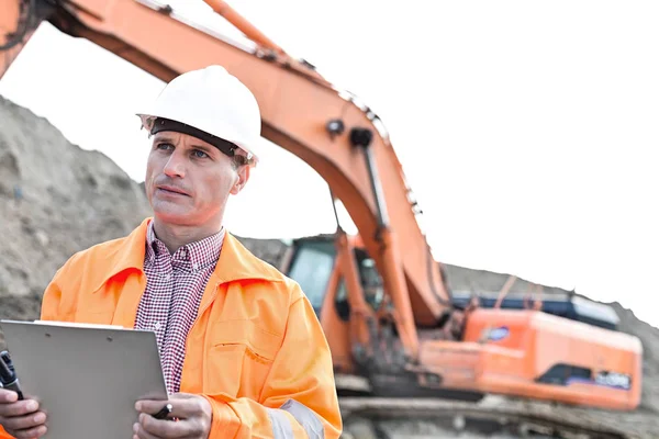 Supervisor looking away while holding clipboard — Stock Photo, Image