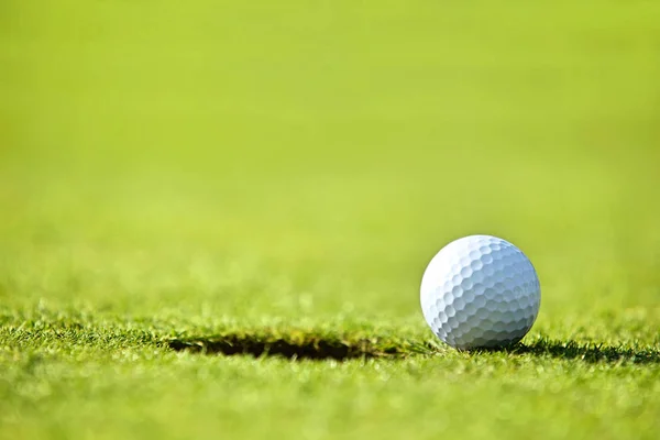 Golf ball near hole — Stock Photo, Image