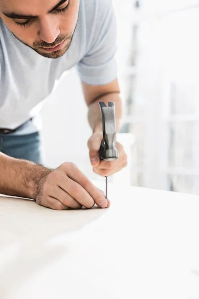 Mann nagelt in Tisch — Stockfoto