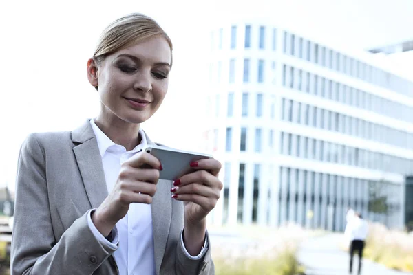 Mensagens de mulher de negócios através de telefone inteligente — Fotografia de Stock
