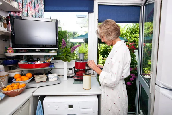Mulher sênior preenchendo café expresso em titular — Fotografia de Stock