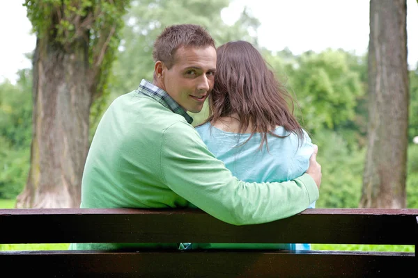 Man with girlfriend sitting on bench — Stock Photo, Image