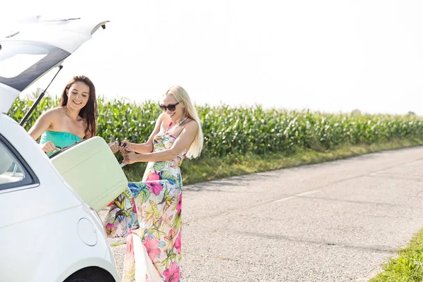 Women loading luggage in car trunk — Stock Photo, Image