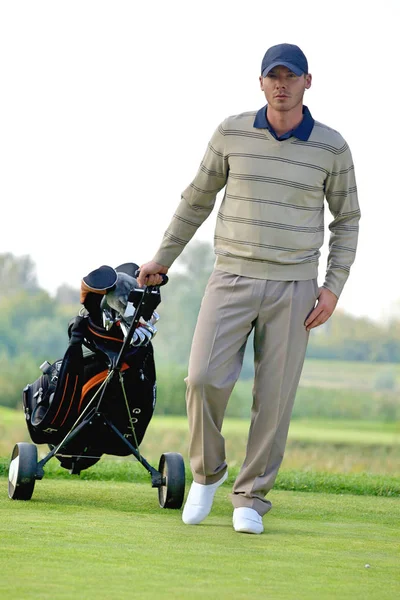 Homme portant chariot avec sac de golf — Photo