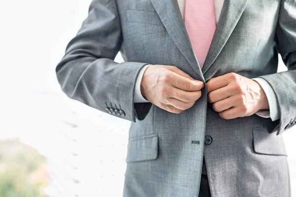 Empresário abotoando seu blazer — Fotografia de Stock