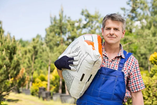 Trädgårdsmästare bära säck — Stockfoto