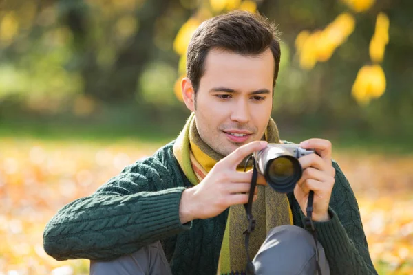 Człowiek ogląda fotografie w cyfrowy aparat fotograficzny — Zdjęcie stockowe