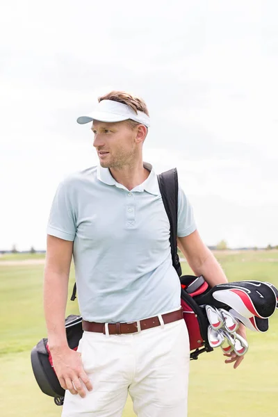 Hombre reflexivo llevando bolsa de golf — Foto de Stock