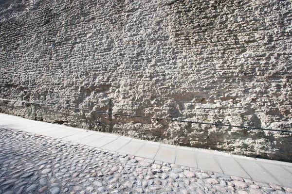 Stenen muur en geplaveide straat — Stockfoto