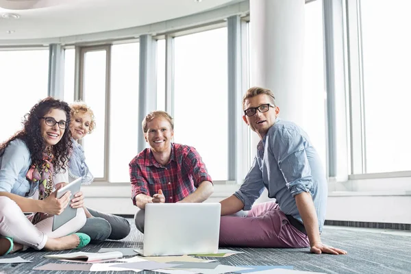 Zufriedene Geschäftsleute, die am Boden arbeiten — Stockfoto