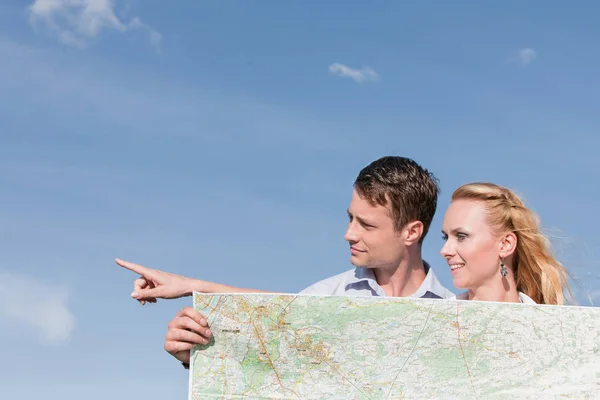 Man håller karta medan kvinna som pekar — Stockfoto