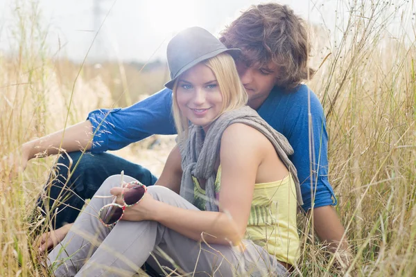 Woman sitting with loving man in field — Stock Photo, Image
