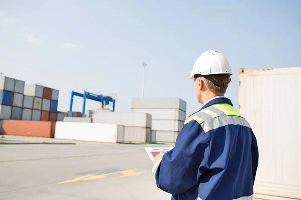 Worker with clipboard in shipping yard — Stock Photo, Image