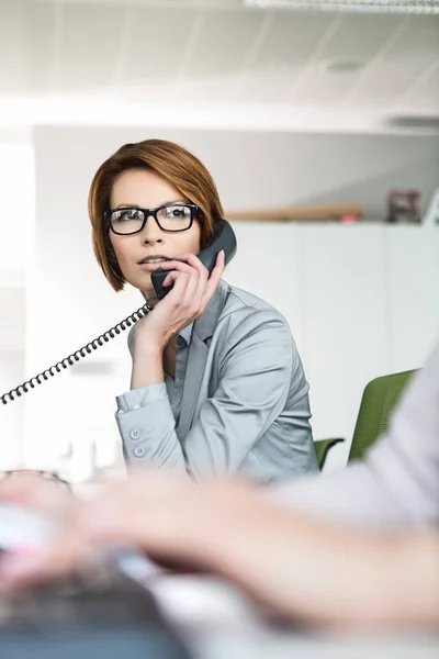 Zakenvrouw die telefoon in kantoor gebruikt — Stockfoto