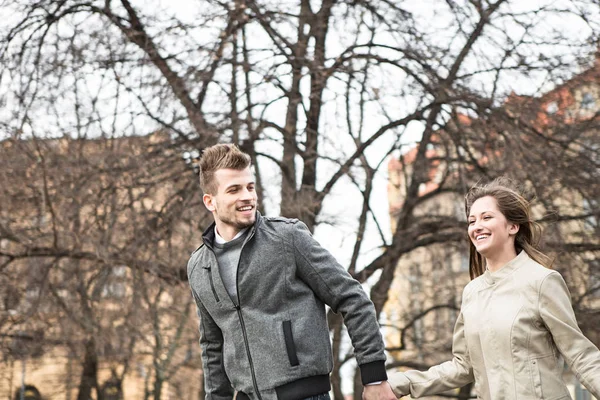 Young man and woman holding hands — Stock Photo, Image