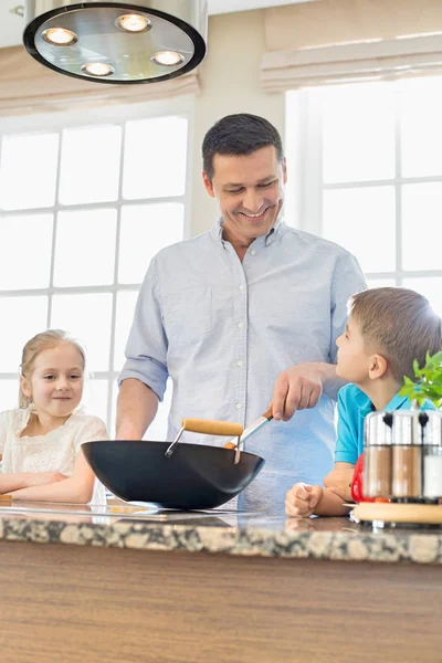 Homem com crianças preparando comida — Fotografia de Stock