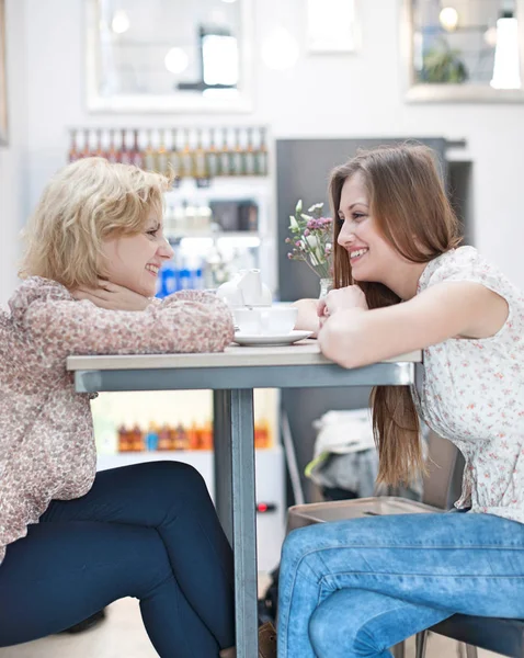 Kvinnliga vänner sitter vid café bord — Stockfoto