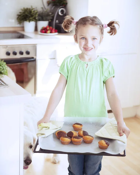 Girl holding baking tray — Stock Photo, Image