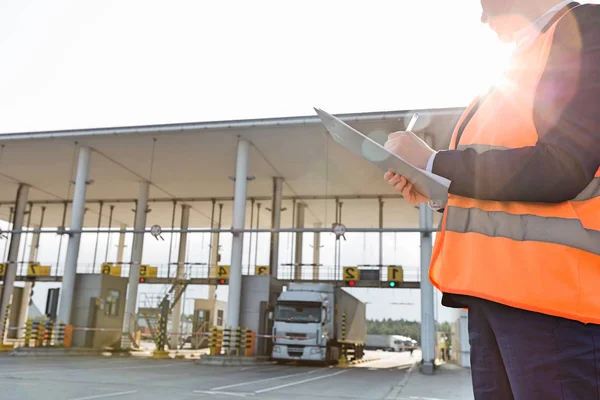 Arbeiterinnen schreiben auf Klemmbrett — Stockfoto