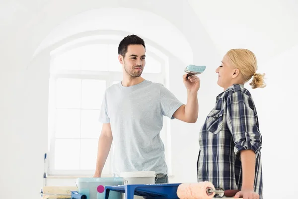 Hombre juguetón poniendo pintura en la mujer —  Fotos de Stock