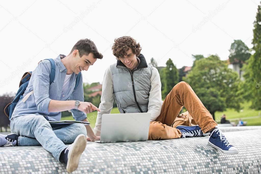Male college friends with laptop