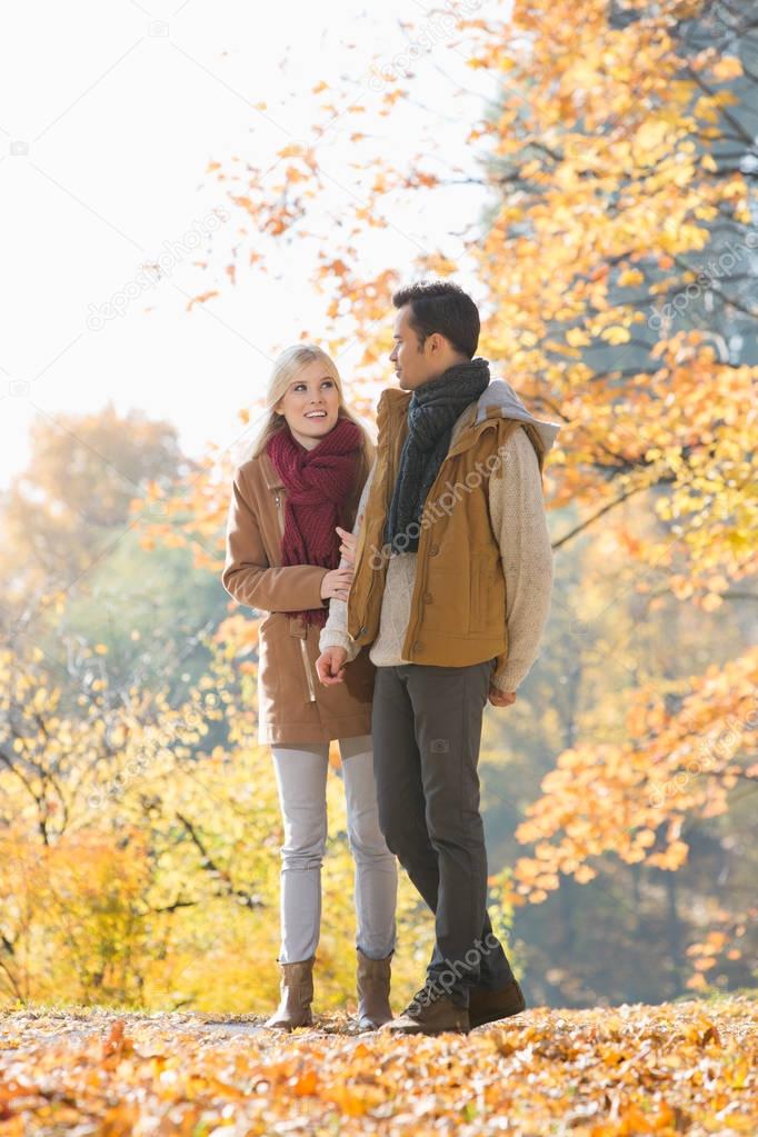 couple walking in park during autumn