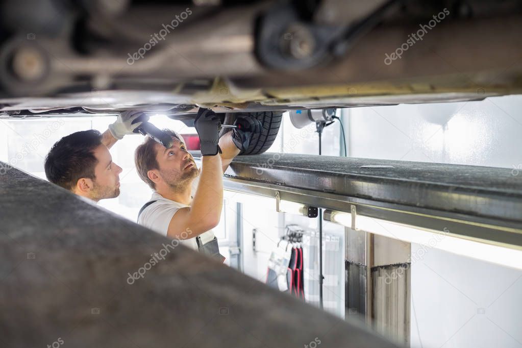 Maintenance engineers repairing car