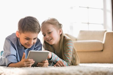 Erkek ve kız kardeş dijital tablet kullanıyor.