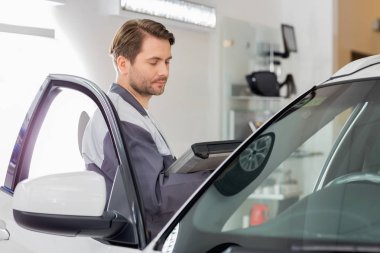 Araba incelenmesi sırasında mühendis holding tablet