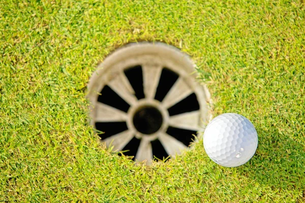 구멍 근처 골프 공 — 스톡 사진