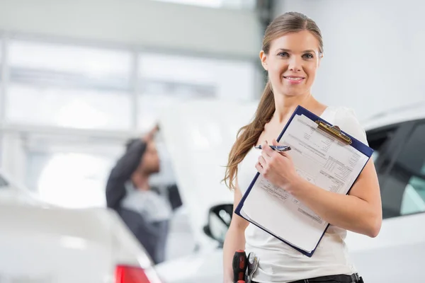 Reparatie van de vrouwelijke werknemer in auto werkplaats — Stockfoto