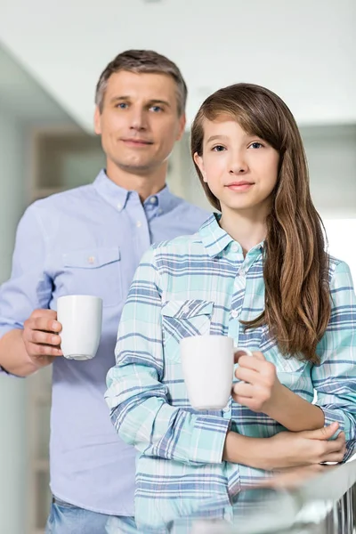 Father and daughter holding coffee cups — Stock Photo, Image