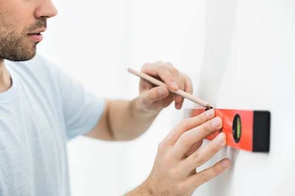 Mann markiert Wand mit Ebene — Stockfoto