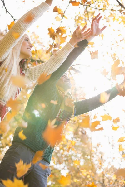 Pár těší klesající podzimní listí — Stock fotografie