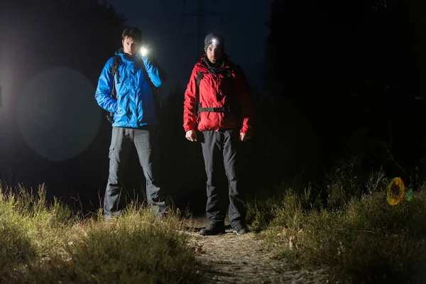 Männliche Wanderer mit Taschenlampen in der Nacht — Stockfoto