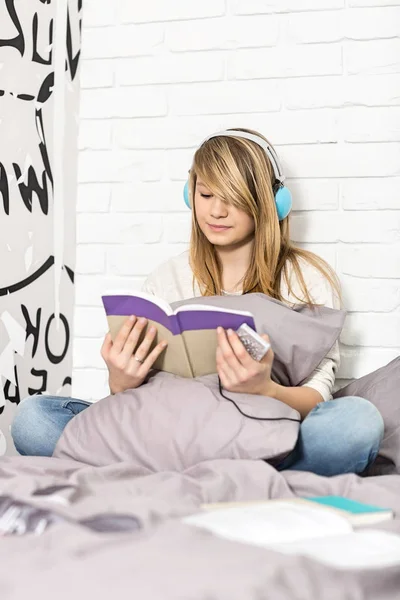 Girl reading book in bedroom — Stock Photo, Image