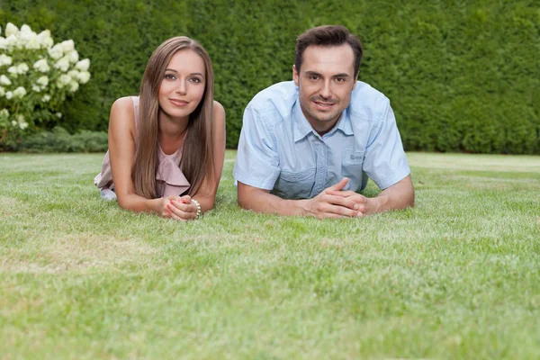 Couple lying on grass in park — Stock Photo, Image