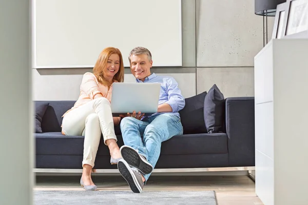 Smiling couple using laptop — Stock Photo, Image