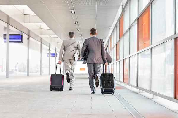 Businessmen with luggage running