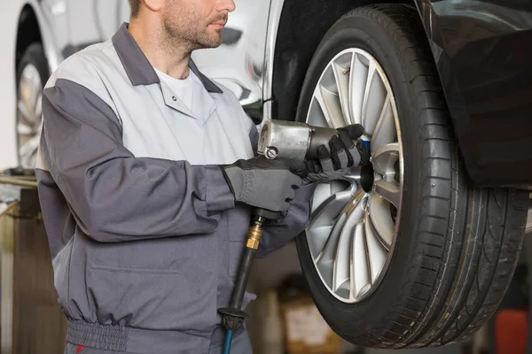 Mechanic repairing car's wheel — Stock Photo, Image