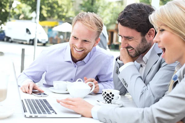 Vrolijke ondernemers met behulp van laptop — Stockfoto