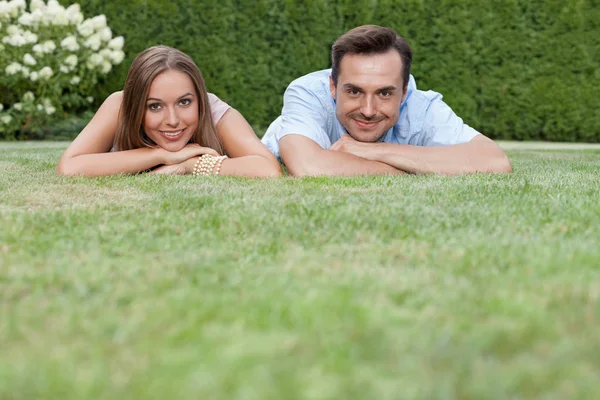 Casal relaxante na grama no parque — Fotografia de Stock