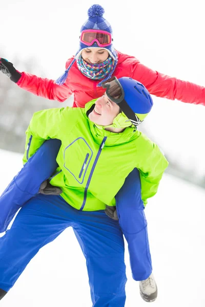 Mann gibt Frau Huckepack-Fahrt — Stockfoto