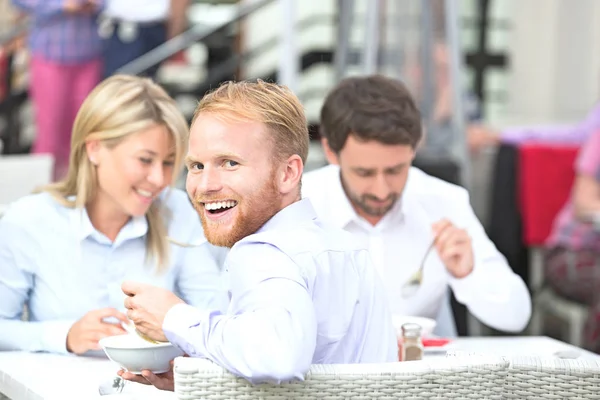 Businessman sitting with colleagues at outdoor restaurant — Stock Photo, Image