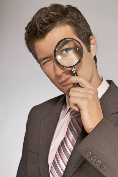 Businessman with magnifying glass — Stock Photo, Image