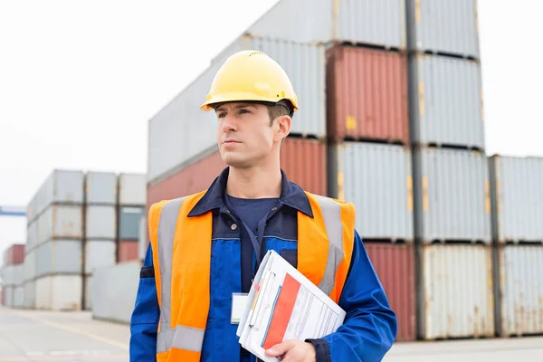 Man with clipboard in shipping yard — Stock Photo, Image