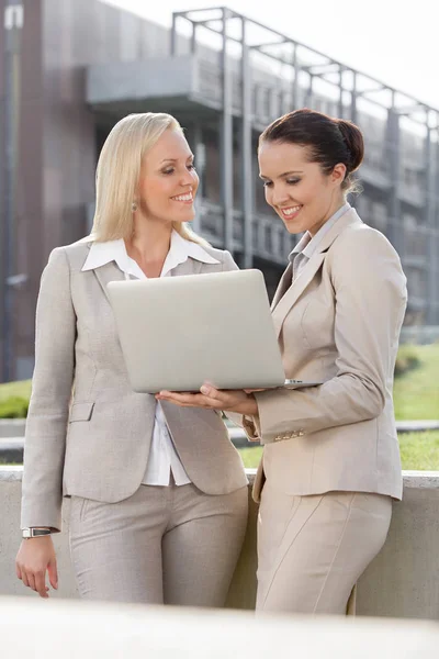 Glada unga affärskvinnor med laptop — Stockfoto