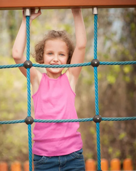 Jong meisje op klimmen net — Stockfoto