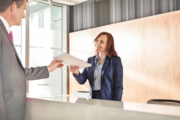 Affärsman mottagningsdokument från receptionist — Stockfoto